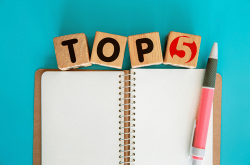 Montaje fotográfico con cuaderno y bolígrafo, simbolizando notas y haciendo referencia a la placa TOP5.