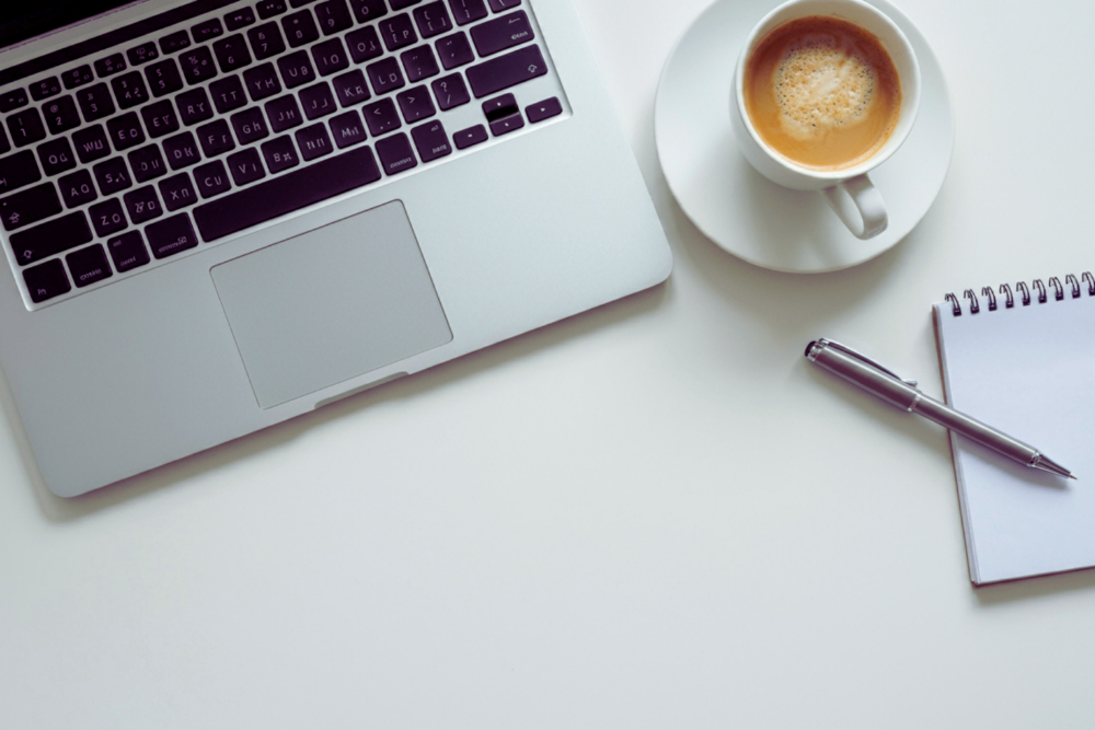 Una persona feliz trabajando desde casa con un portátil, un entorno organizado, luz natural, un tono claro y moderno. La Era del Home Office: 6 Consejos Esenciales para Prosperar en el Trabajo Remoto
