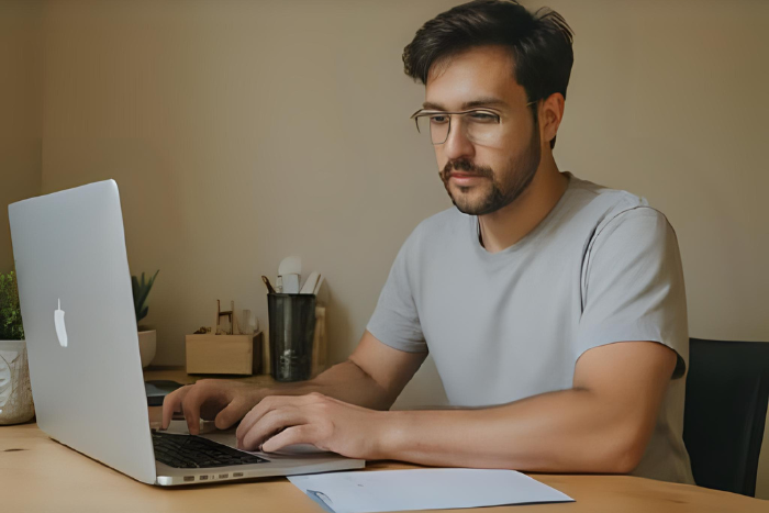 Una persona que empieza a trabajar a distancia desde casa, con un simple escritorio, una lista de control a su lado, una sensación de novedad y concentración.